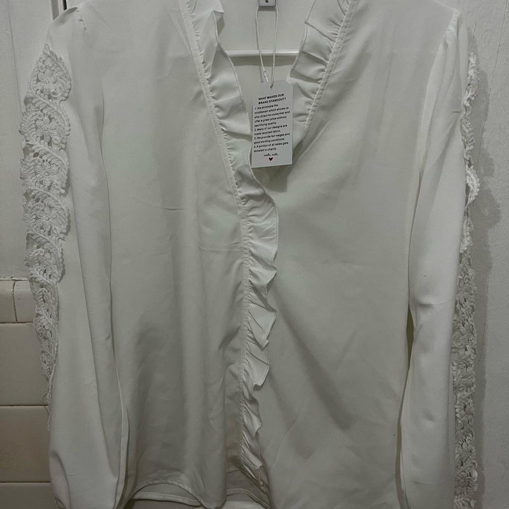 Size small new, white long sleeve blouse. Never worn. Pace trim.